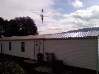 New metal roof on a single wide mobile home with a TV antenna in Reynolds